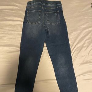 Distressed jean legging by Spanx. There is a rip on the seam.